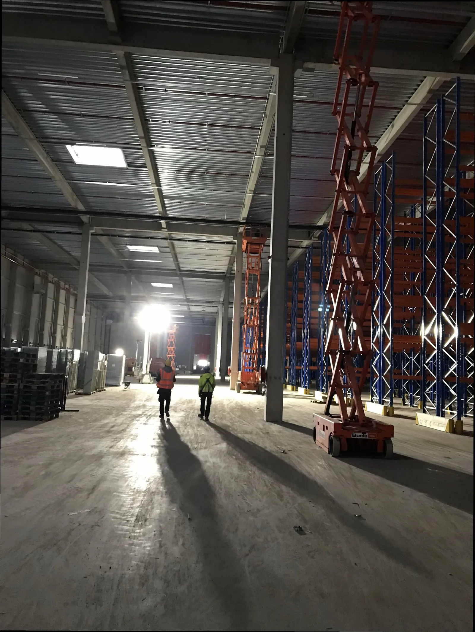 Warehouse hall with cable routes installed from scissor lifts