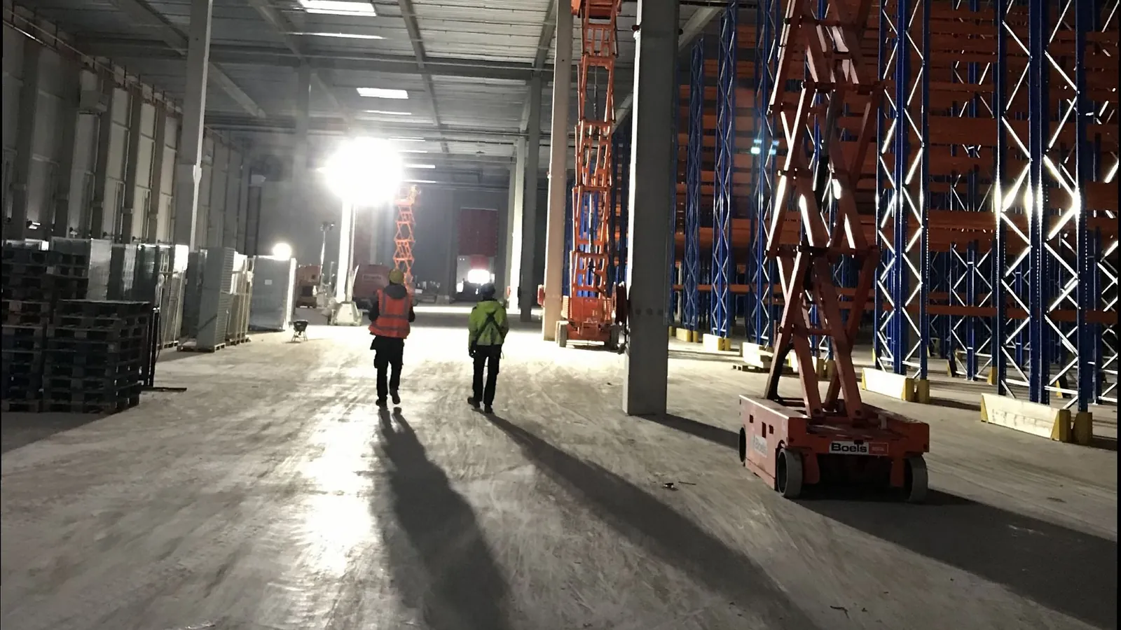 Warehouse hall with cable routes installed from scissor lifts